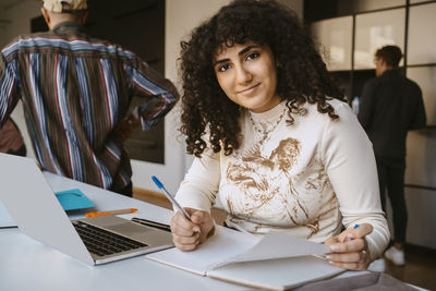 Portrait of young woman with curly hair studying at community college