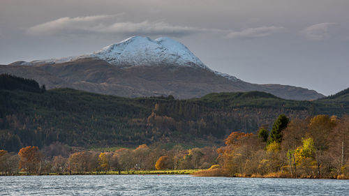 Looking across loch ard in the scottish highlands to the snowy summit of ben lomond