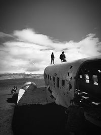 People standing on airplane against sky