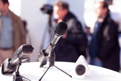 Close-up of microphone with men in background