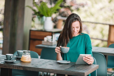 Young woman sitting on table at cafe