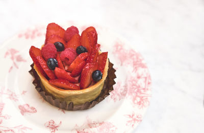 Fresh homemade fruit tart with strawberry isolated on white table, top view. selective focus.