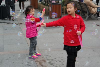 Full length of siblings enjoying in city