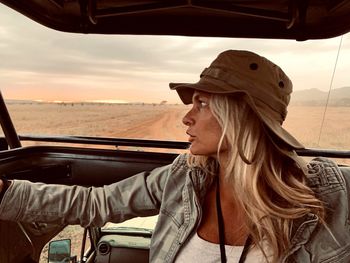 Woman with blond hair sitting in safari vehicle at national park