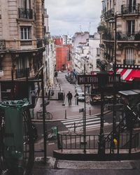 Buildings by street in city against sky