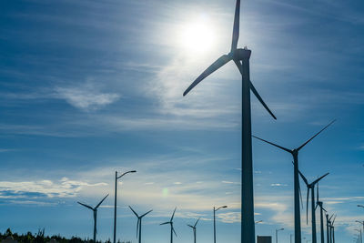 Low angle view of wind turbine against sky during sunset