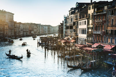 Gondolas in canal amidst buildings