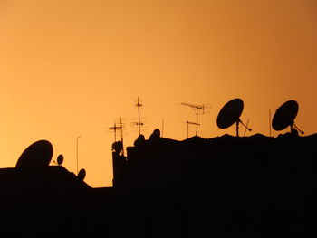 Silhouette people against clear sky at sunset