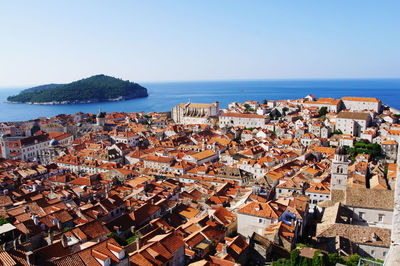 High angle view of townscape by sea against clear sky