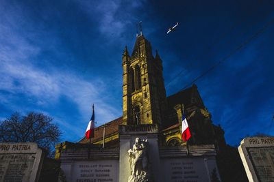 Low angle view of flag against sky in city