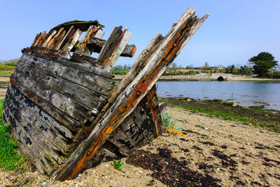 Abandoned boat on beach against clear sky