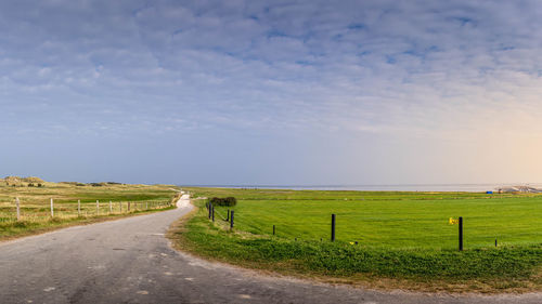 People walking on field against sky