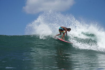 Man surfing in sea against sky