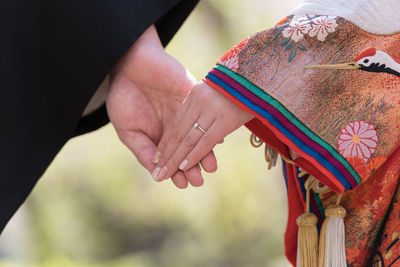 Midsection of couple holding hands