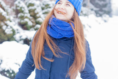 Portrait of smiling young woman in snow