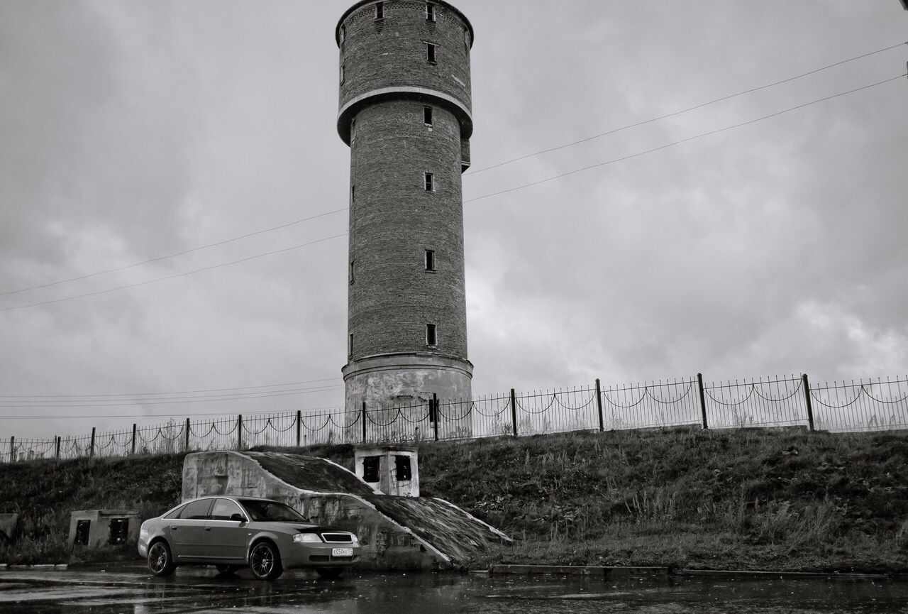 VIEW OF OLD TOWER ON FIELD AGAINST SKY