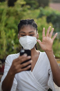 Young black woman in face mask doing a video call