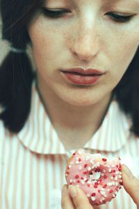 Close-up of young woman holding cake