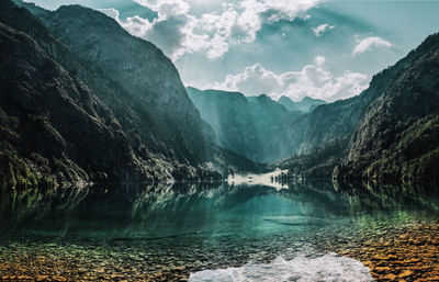 Scenic view of lake by mountains against sky