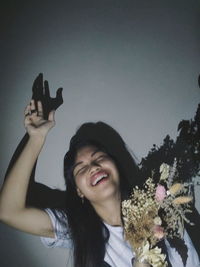 Portrait of smiling young woman against sky