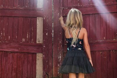 Young woman standing against door