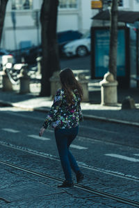 Rear view of woman walking on street in city