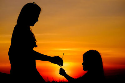 Silhouette of woman and child at sunset