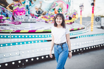 Beautiful asian young woan in an amusement park, smiling
