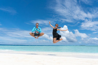 People enjoying at beach against sky
