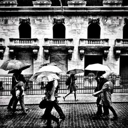 People walking on wet street during rainy season