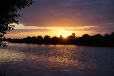 Scenic view of lake against orange sky