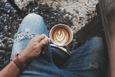 Midsection of man holding coffee cup