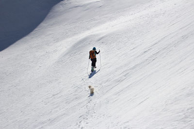 Full length rear view of man walking on snow