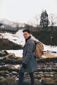 Young man standing on snow covered land