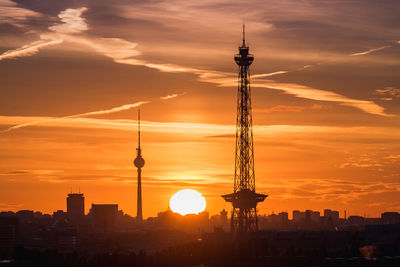 Silhouette fernsehturm and television tower against dramatic sky during sunset