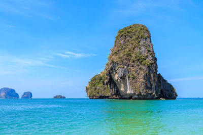 Rock formation in sea against blue sky