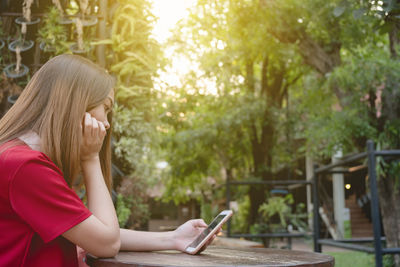 Side view of woman using mobile phone