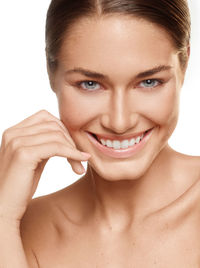 Close-up portrait of a smiling young woman over white background