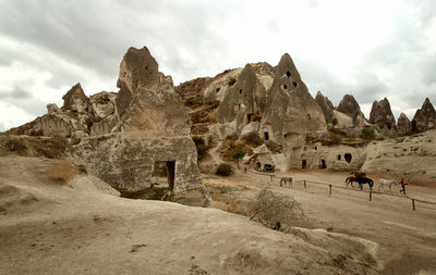 Rock formations against cloudy sky