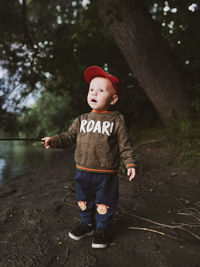 Full length of cute boy standing on tree