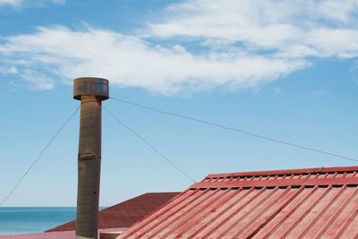 Low angle view of chimney on roof against sky