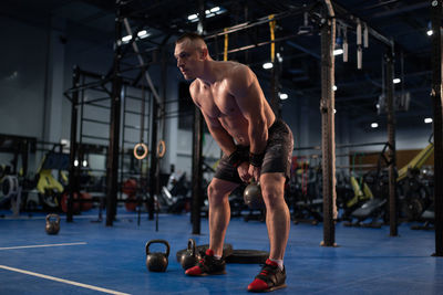 Muscular man exercising with kettlebell