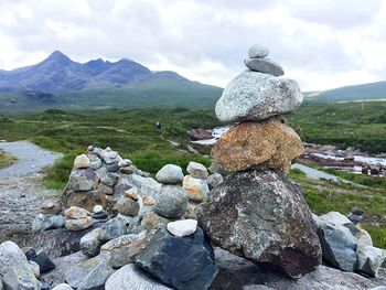 Stack of pebbles on mountain against sky
