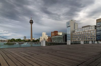 Modern buildings in city against cloudy sky