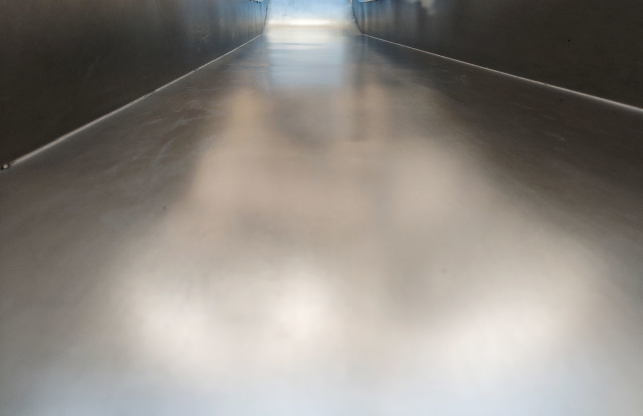 HIGH ANGLE VIEW OF ILLUMINATED EMPTY CORRIDOR OF BUILDING