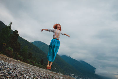 Full length of young woman against mountain