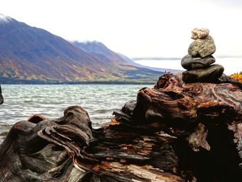 Close-up of statue by rock against sky