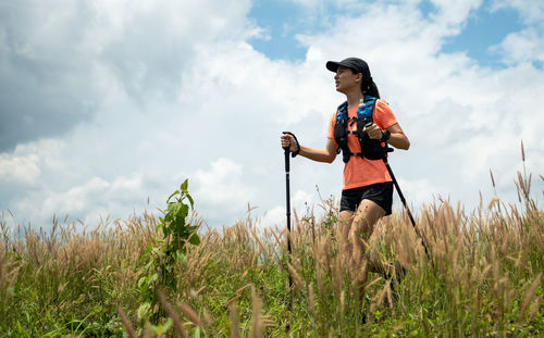 Young woman walking on grassy land