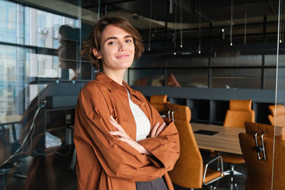 Portrait of young woman standing in factory