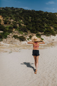 Rear view of woman walking on beach